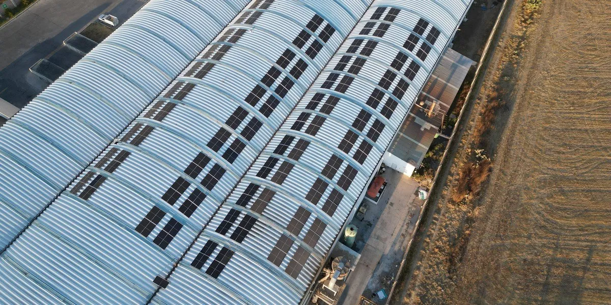 Vista aérea de una instalación fotovoltaica sobre el techo de una nave industrial.